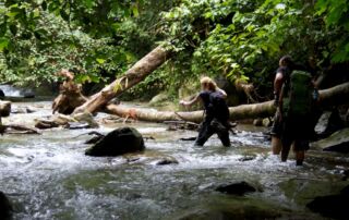 Crossing the river during the jungle trek tour in BUkit lawang